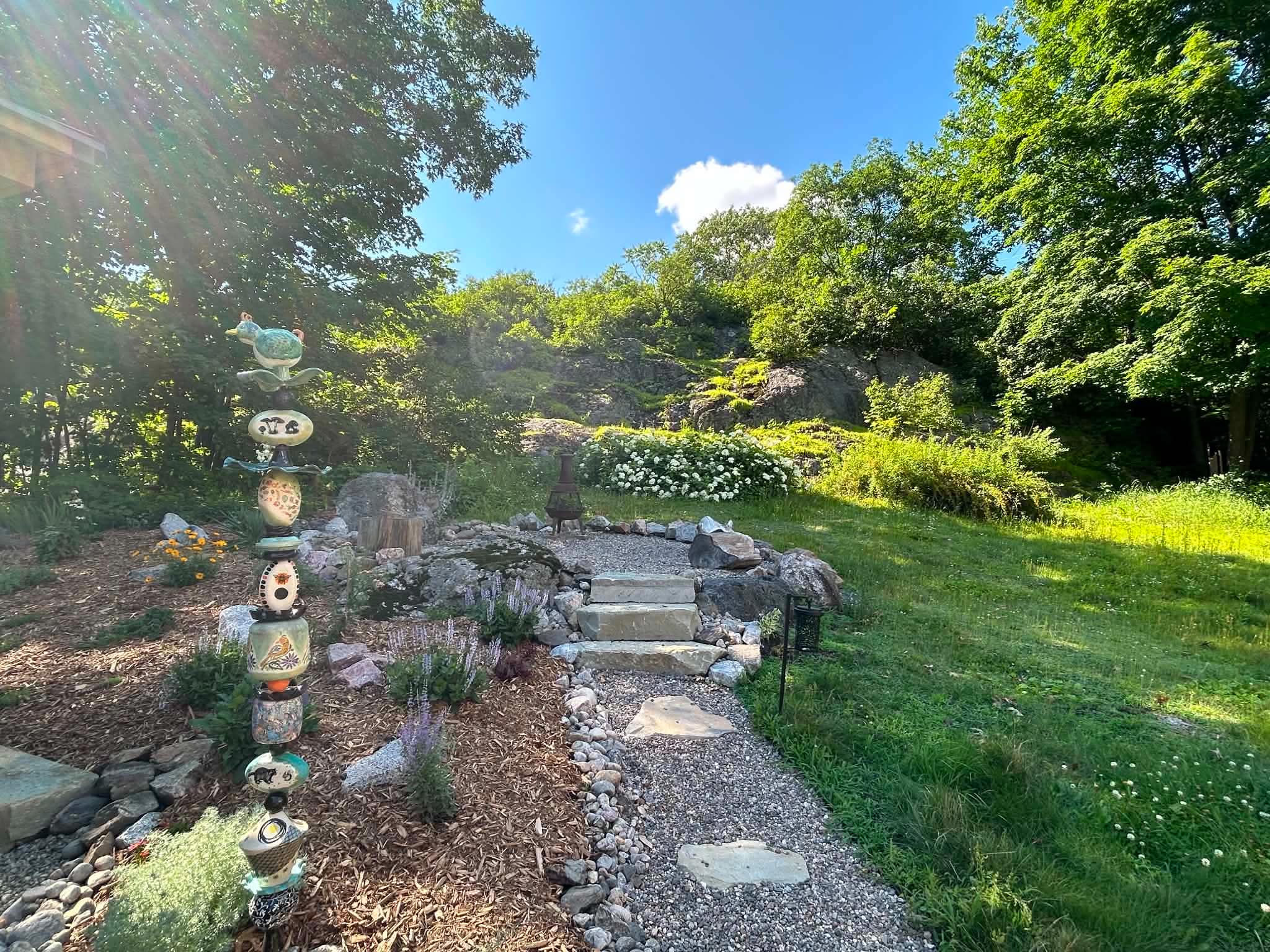 Landscaped garden, natural rock feature and mature trees at 563 Route 105