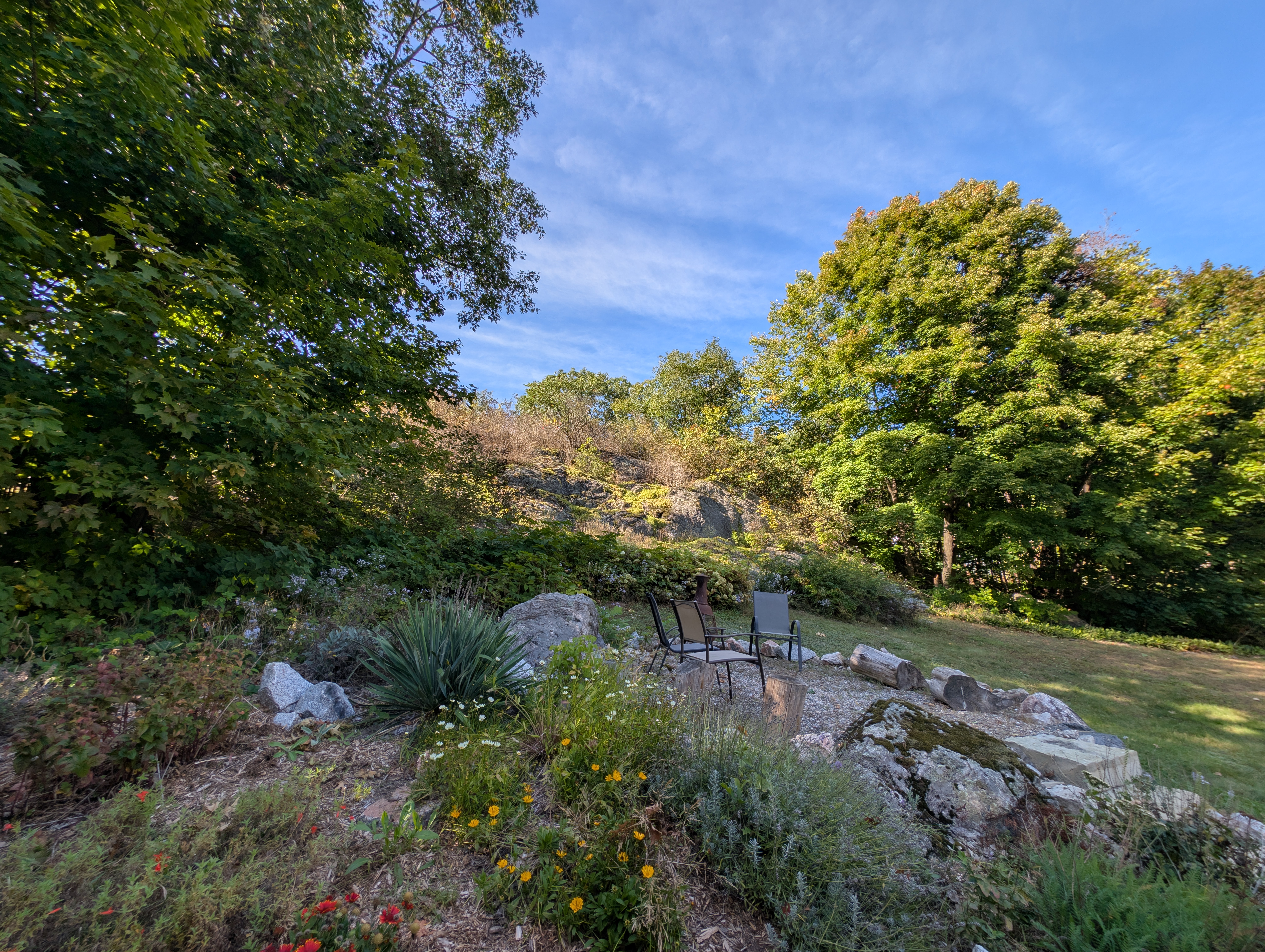 Natural rock garden, mature trees and firepit at 563 Route 105